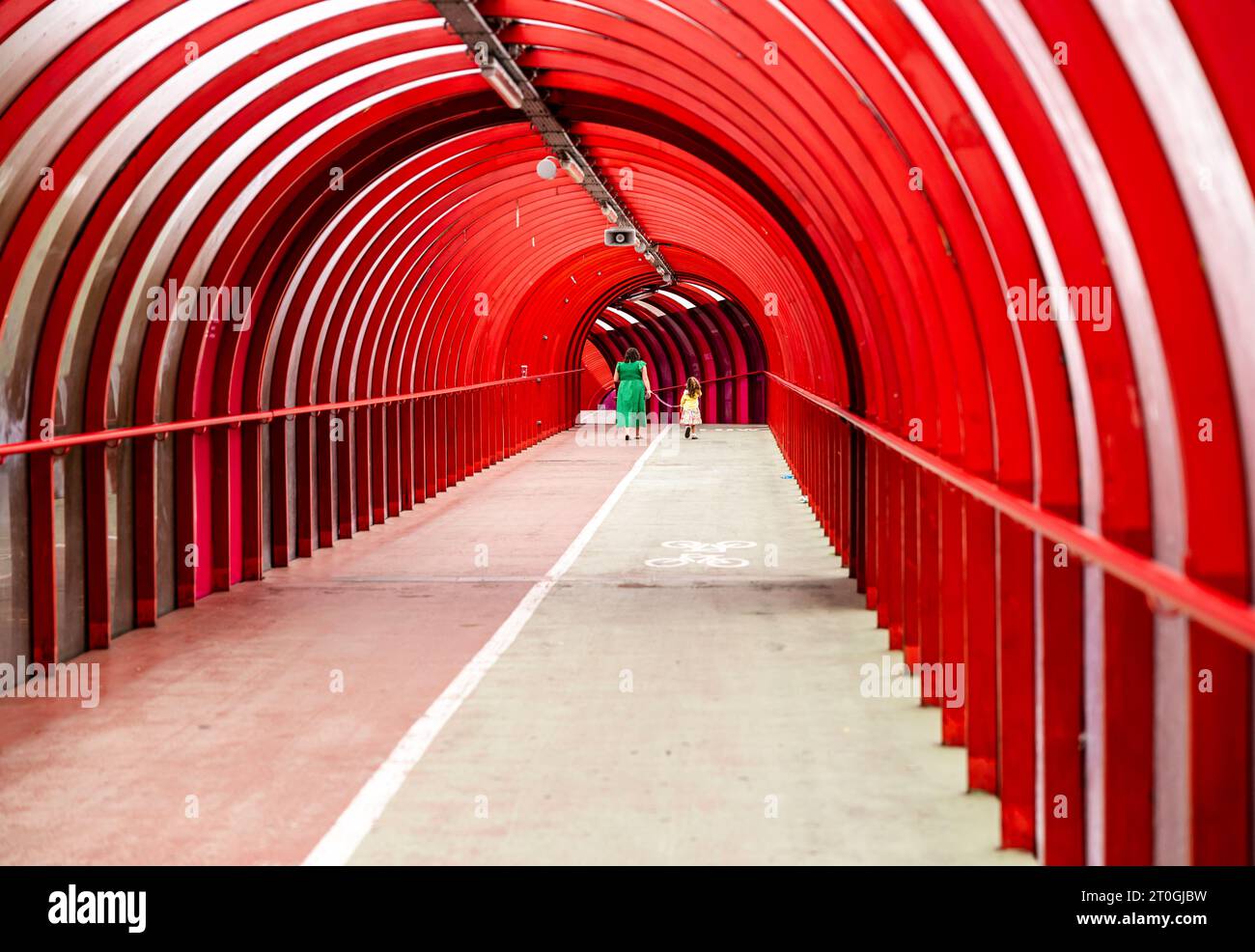 Steel and curved perspex covered walkway and cycle path bridging the