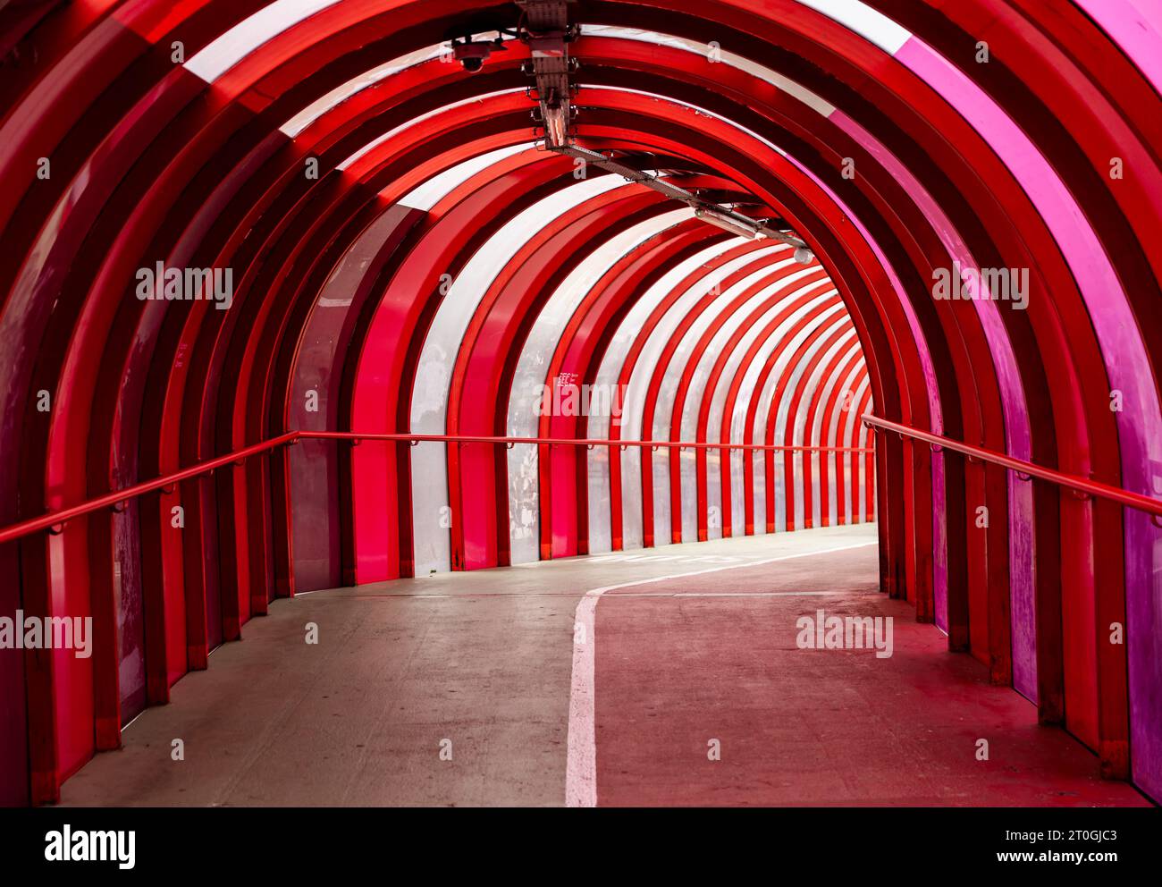 Steel and curved perspex covered walkway and cycle path bridging the