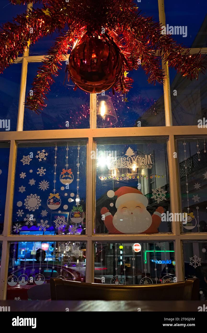Looking out of a Christmas-decorated pub window at dusk Stock Photo
