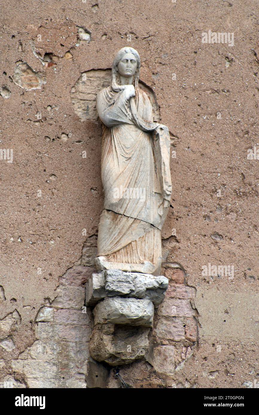 antica statua romana sulle mura di Spello Stock Photo