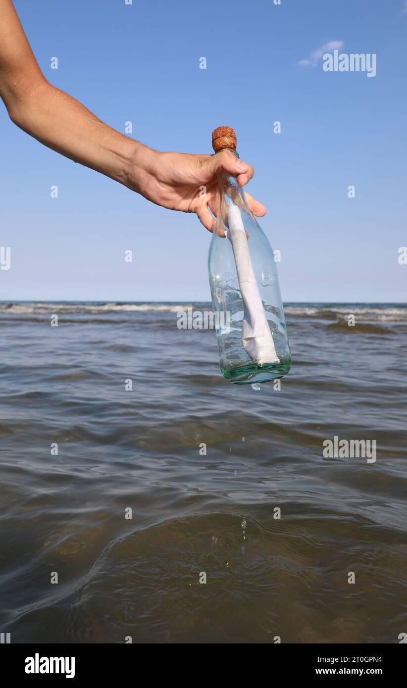 Person finding a message in a bottle hi-res stock photography and ...