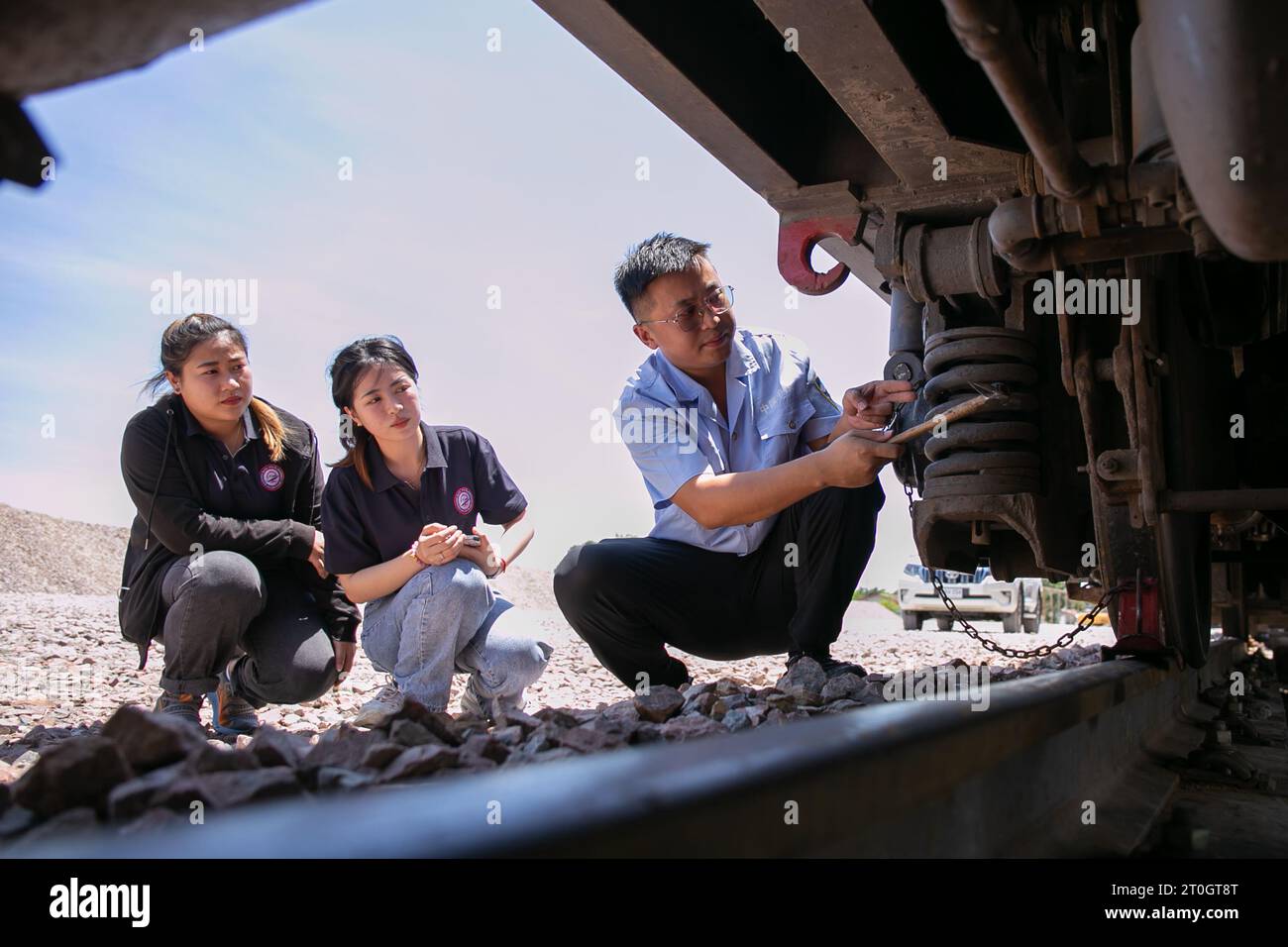 Beijing, Laos. 12th Sep, 2021. Sida Phengphongsawanh (C) learns to inspect a train from a Chinese instructor at the China Railway No. 2 Engineering Group (CREC-2) railing base for the China-Laos railway, on the northern outskirts of Vientiane, capital of Laos, Sept. 12, 2021. Credit: Kaikeo Saiyasane/Xinhua/Alamy Live News Stock Photo