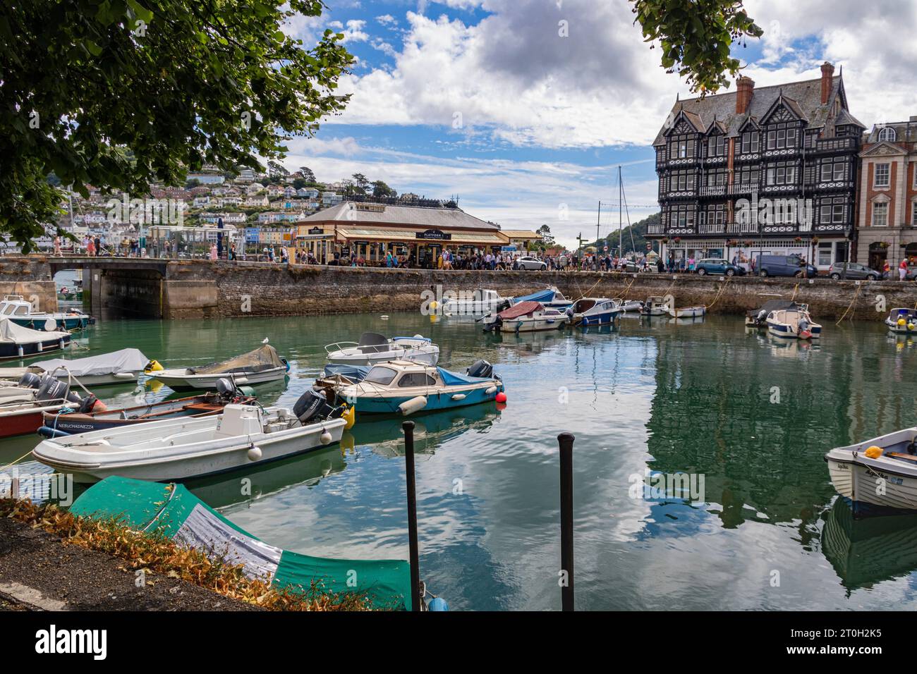 View Looking Across Dartmouth Inner Harbour to the Old Railway Station on the Riverside, Embankment, Surrounding Properties and Reflections Stock Photo