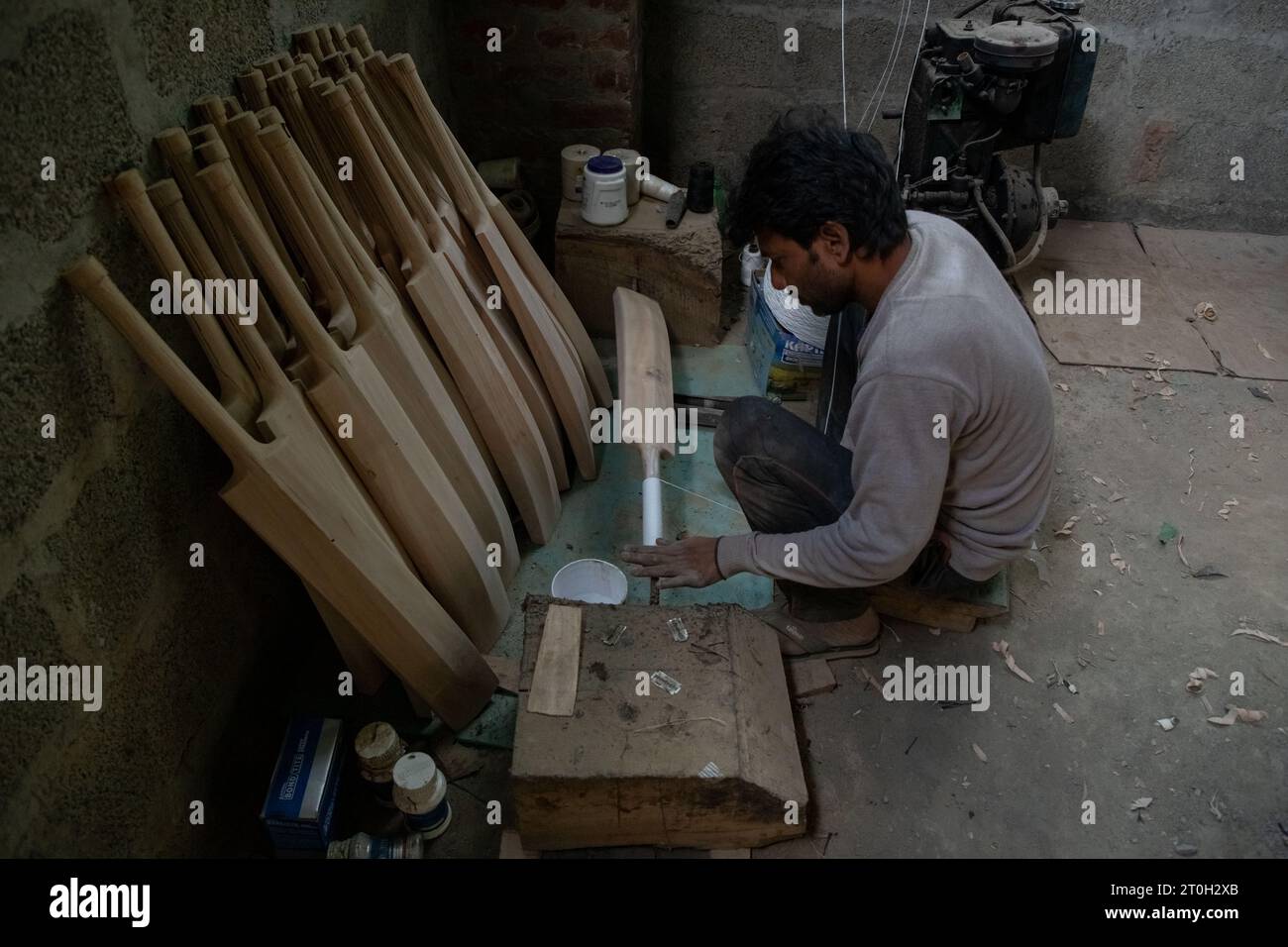 A worker finishes a Kashmiri willow wood cricket bats at a factory in