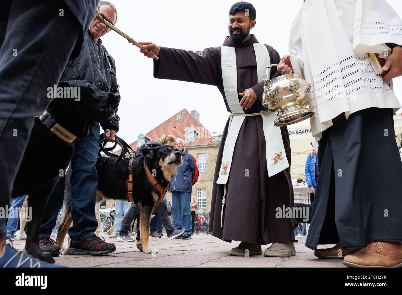 07 October 2023, Lower Saxony, Osnabrück: Father Nijil Chiramal blesses dogs in front of Osnabrück Cathedral. The blessing of animals goes back to World Animal Day, which is also the Catholic day of remembrance for St. Francis of Assisi. The founder of the Franciscan order is considered the patron saint of animals. Photo: Friso Gentsch/dpa Credit: dpa picture alliance/Alamy Live News Stock Photo