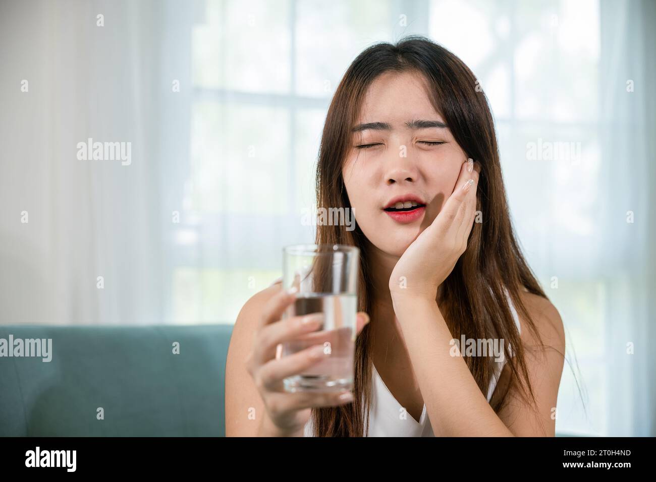 Beautiful female toothache and dental problems touching cheek feeling