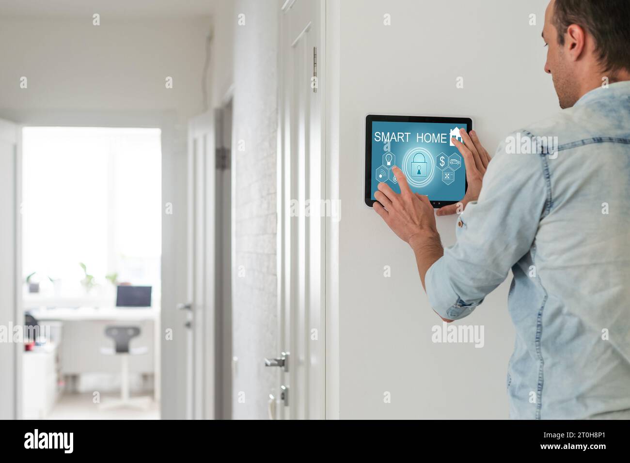 Young electrician installing security alarm on wall Stock Photo