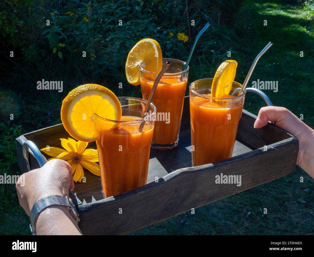 Freshly squeezed juice in juice glasses, carrots, lemon, apple, orange, health drink Stock Photo