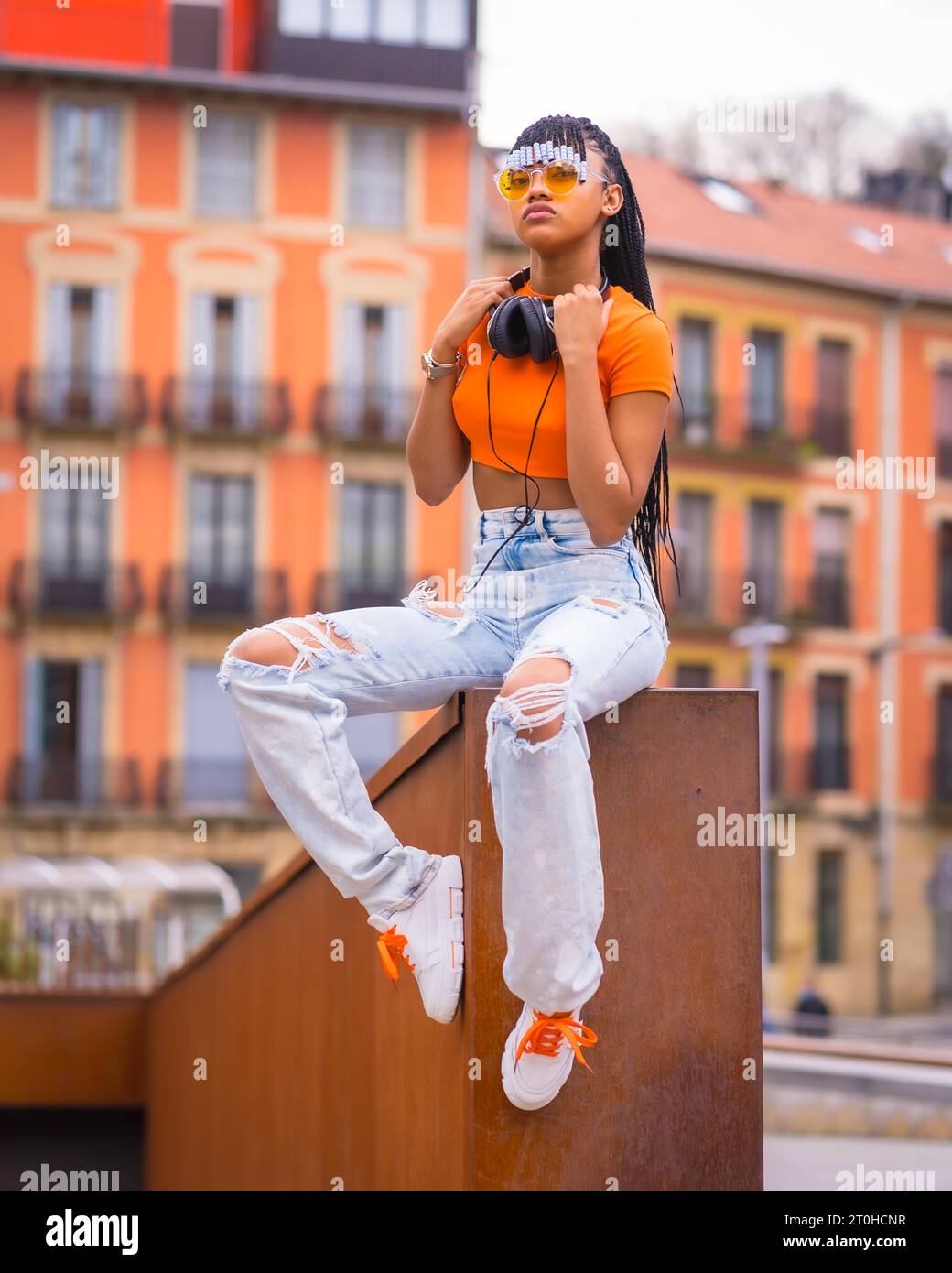 Street Style of a young trap dancer with braids. A beautiful black girl of African ethnic group with t shirt orange sunglasses and cowboy pants Stock Photo Alamy