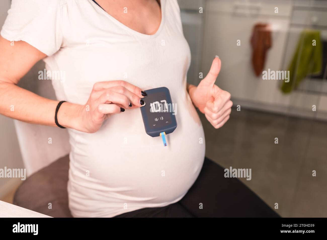 Young pregnant woman performing a gestational diabetes selftest to