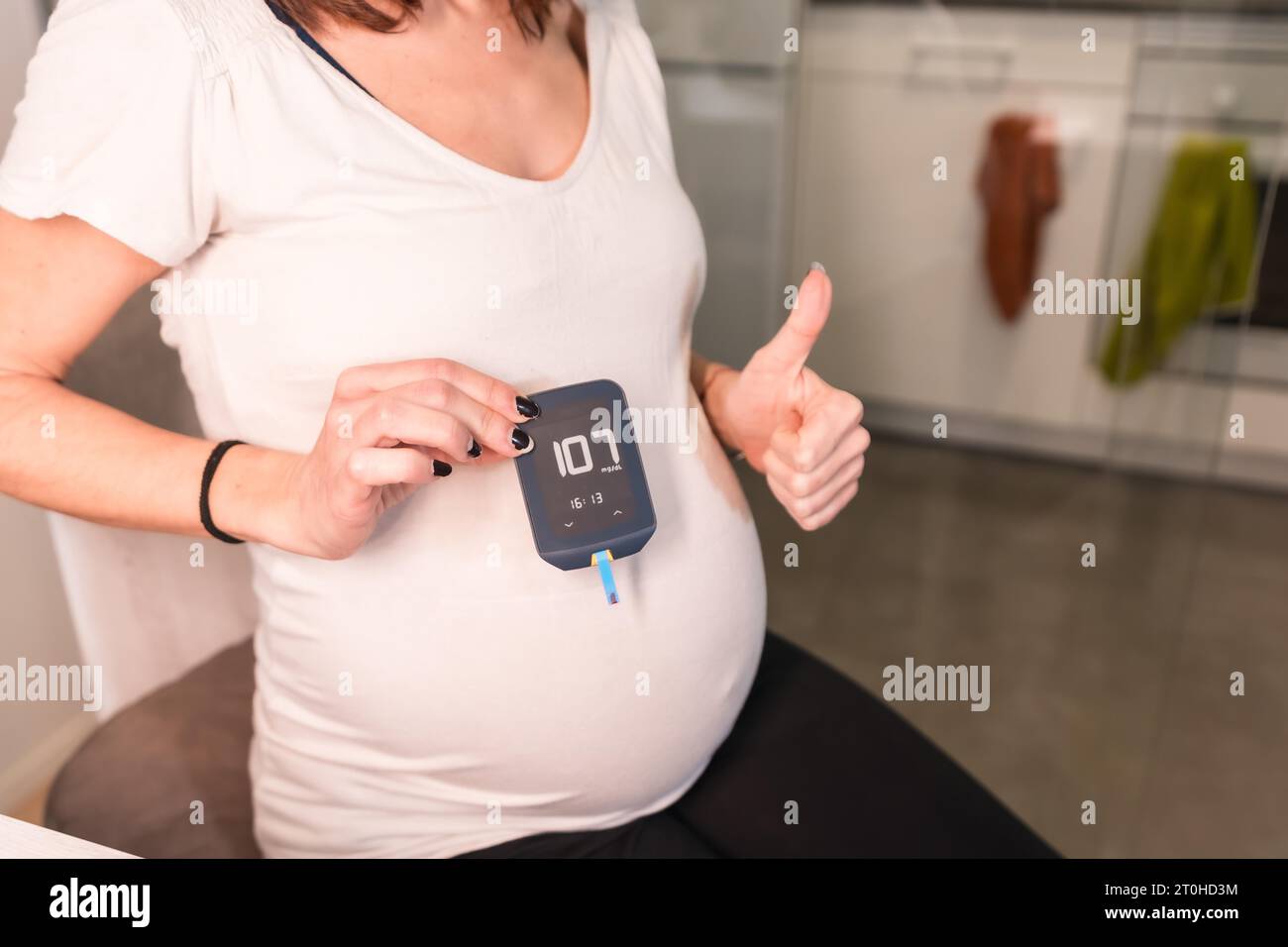 Young pregnant woman performing a gestational diabetes selftest to