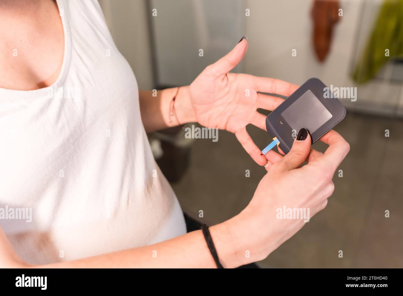 Young pregnant woman performing a gestational diabetes selftest to