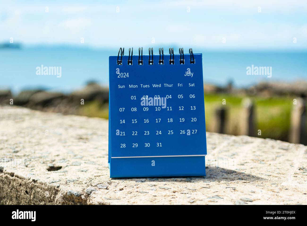 Blue July 2024 calendar on blurred background of blue ocean. 2024 New
