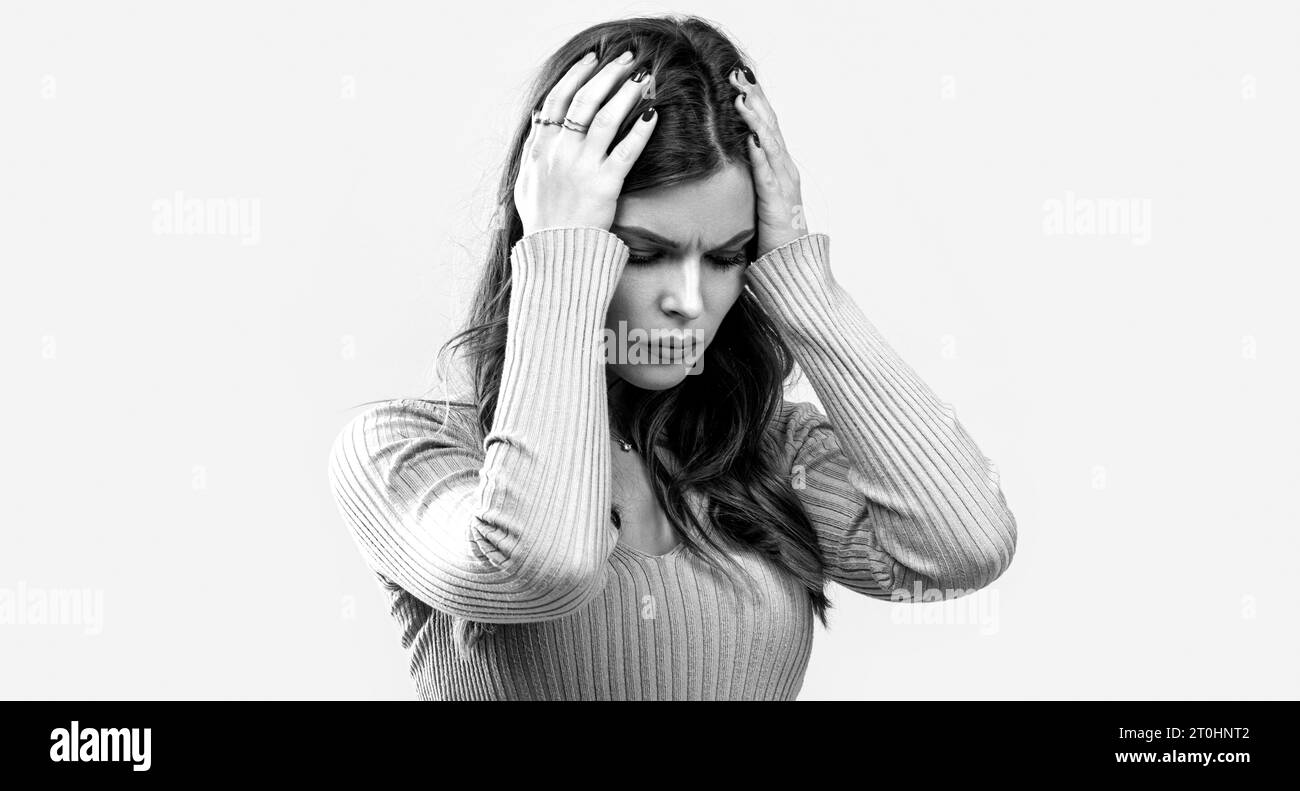 Brunette woman touching her temples feeling stress, on gray background. Woman hard headache holding hands on head. Black and white Stock Photo