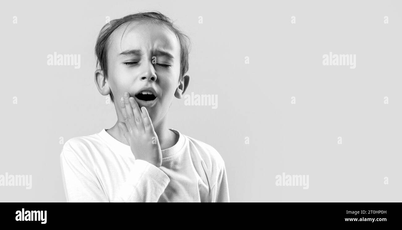 Dentist concept. Child suffer from toothache. Anti toothache remedy. Toothache painkiller. Oral care concepts. Black and white Stock Photo