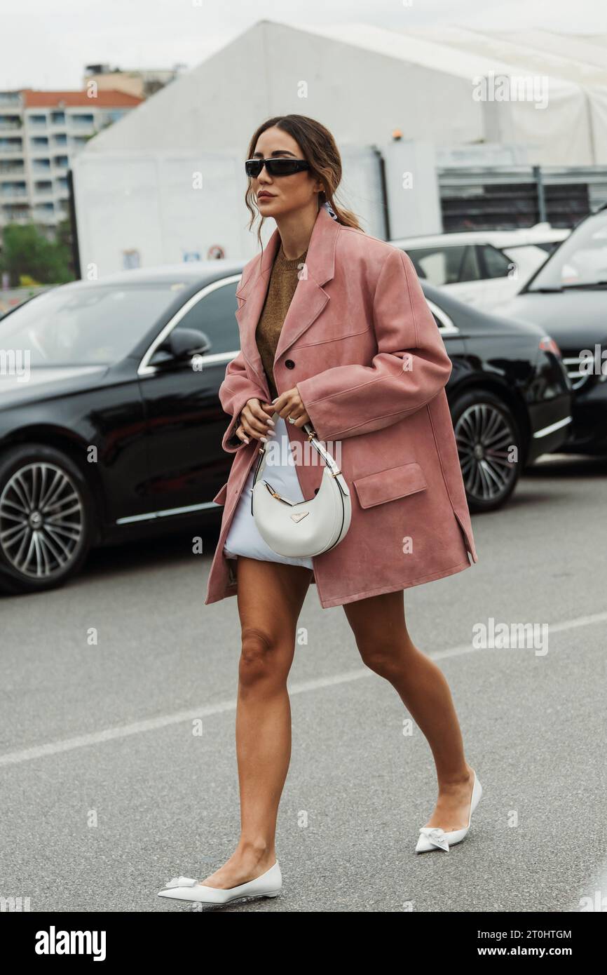 Tamara Kalinic wears a knit pullover, a pink suede oversized jacket, Prada bag and mules, seen outside PRADA show during Milan Fashion Week Womenswear Stock Photo