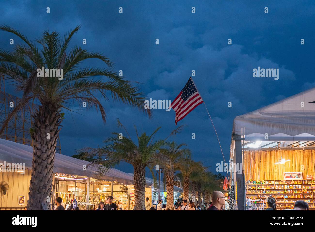 Bangkok, Thailand - August 6, 2023: Train Night Market at Srinakarin (Talad Rot Fai Srinakarin), with palm trees and the American flag Stock Photo