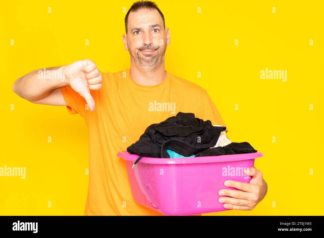 Hispanic man with beard in his 40s holding a laundry basket with angry ...