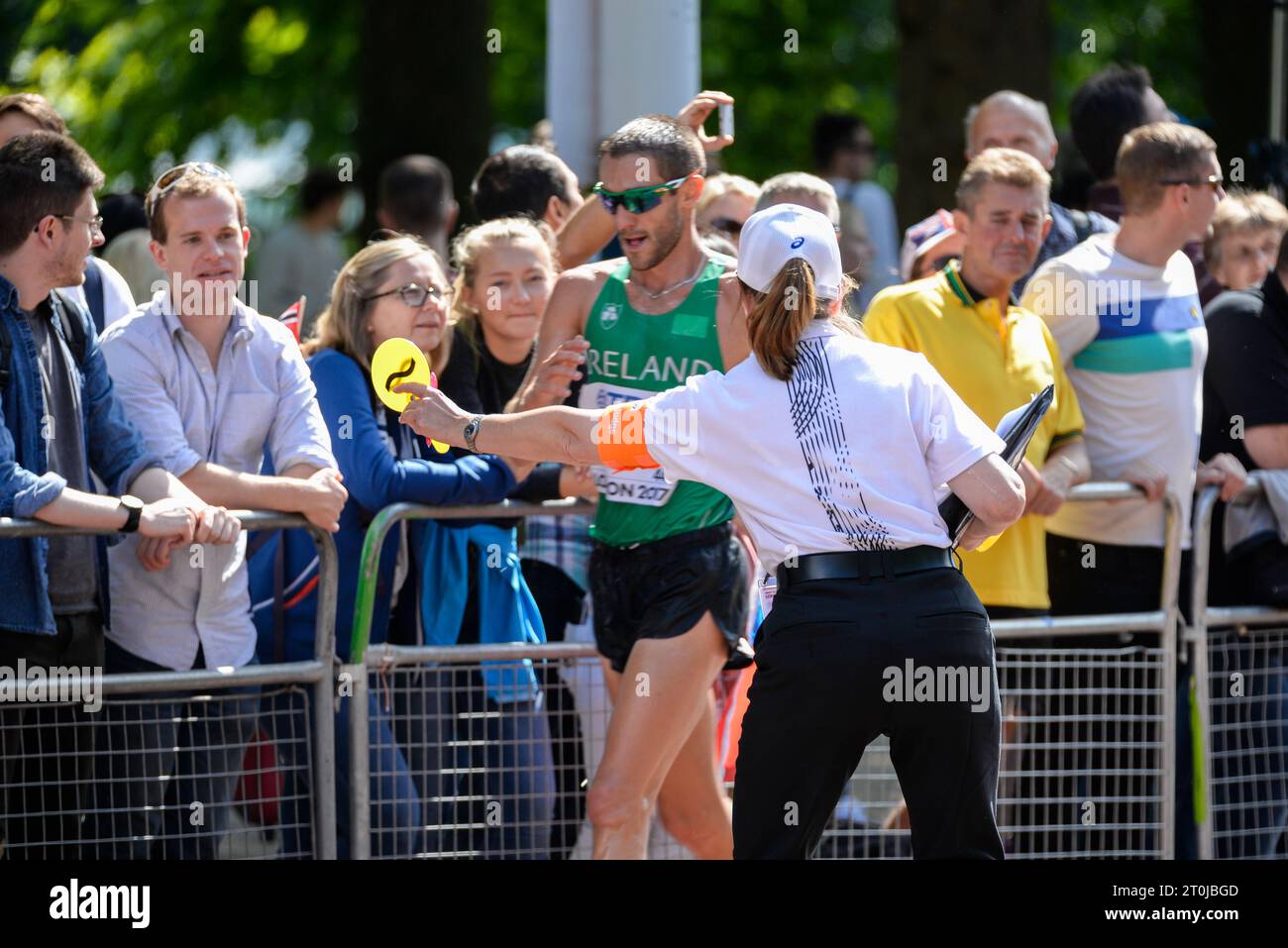 Judge showing a caution paddle to a competing athlete in the IAAF World Athletics Championships 20k walk in The Mall, London, UK. Loss of contact sign Stock Photo