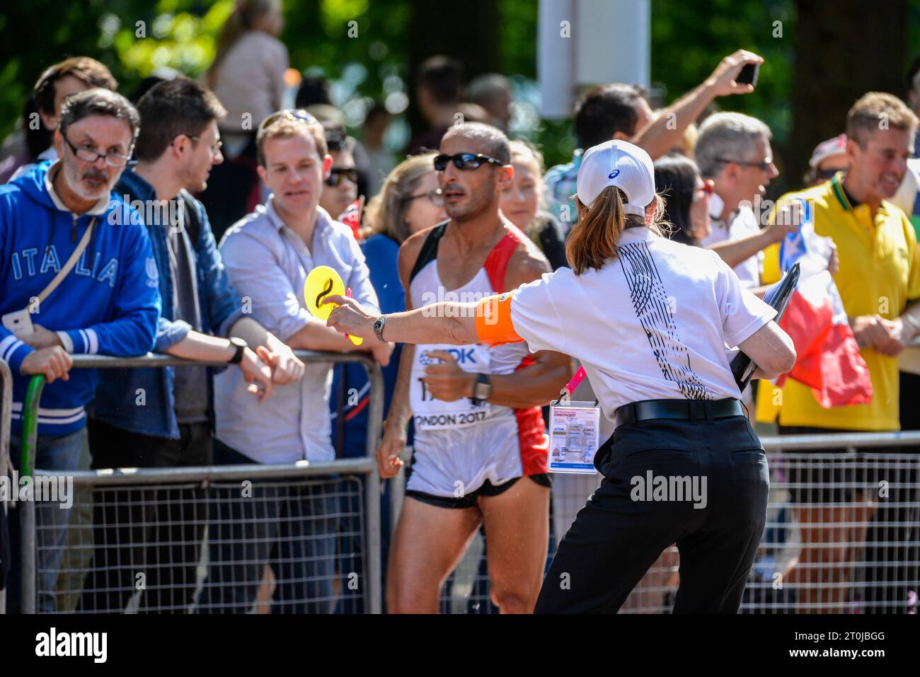 Judge showing a caution paddle to a competing athlete in the IAAF World Athletics Championships 20k walk in The Mall, London, UK. Loss of contact sign Stock Photo