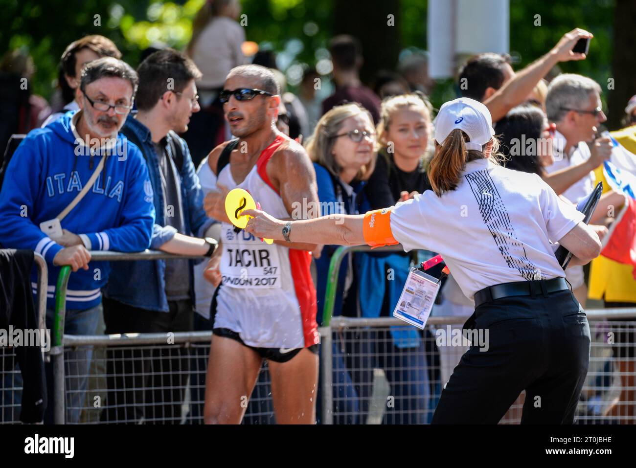 Judge showing a caution paddle to a competing athlete in the IAAF World Athletics Championships 20k walk in The Mall, London, UK. Loss of contact sign Stock Photo