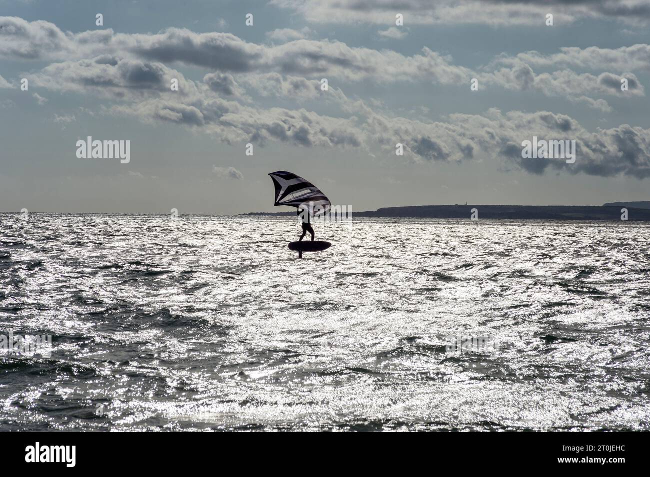 Man with wingfoil sail on the Solent Stock Photo