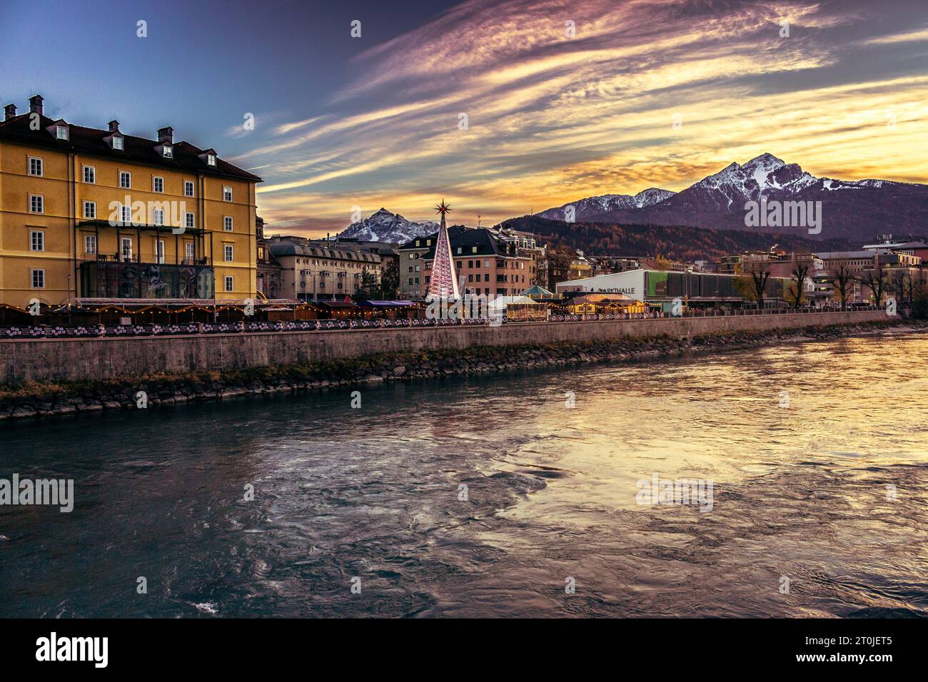 Golden sunset in Innsbruck. Dramatic evening sky in Austria. Innsbuck landmark. River embankment in Tirol. Winter beautiful cityscape. Christmas time. Stock Photo