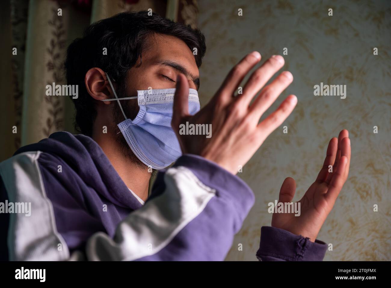 Male wearing mask and praying for allah to protect him from diseases ...