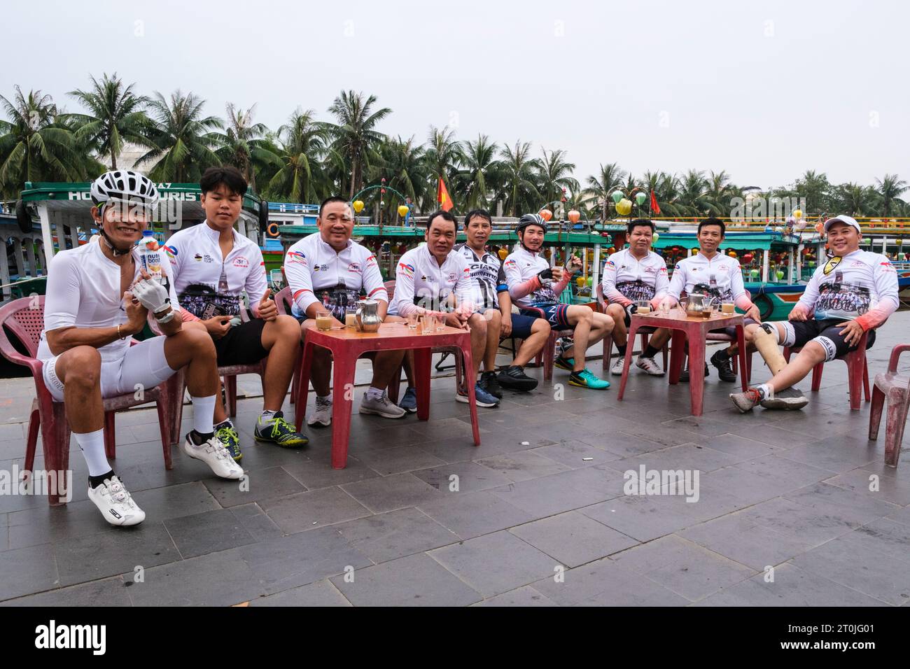 Hoi An, Vietnam. Sports Team Having Morning Coffee at Riverside Sidewalk Cafe. Stock Photo