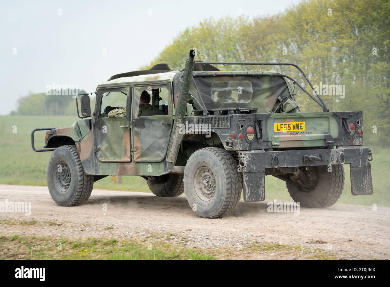 an old military humvee hummer jeep, driving along a dirt track Stock Photo