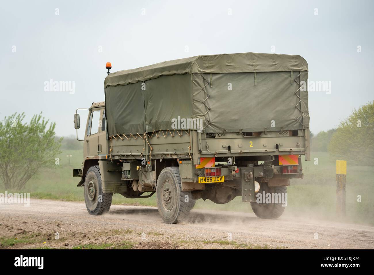 an old military light utiltiy truck, driving along a dirt track Stock Photo