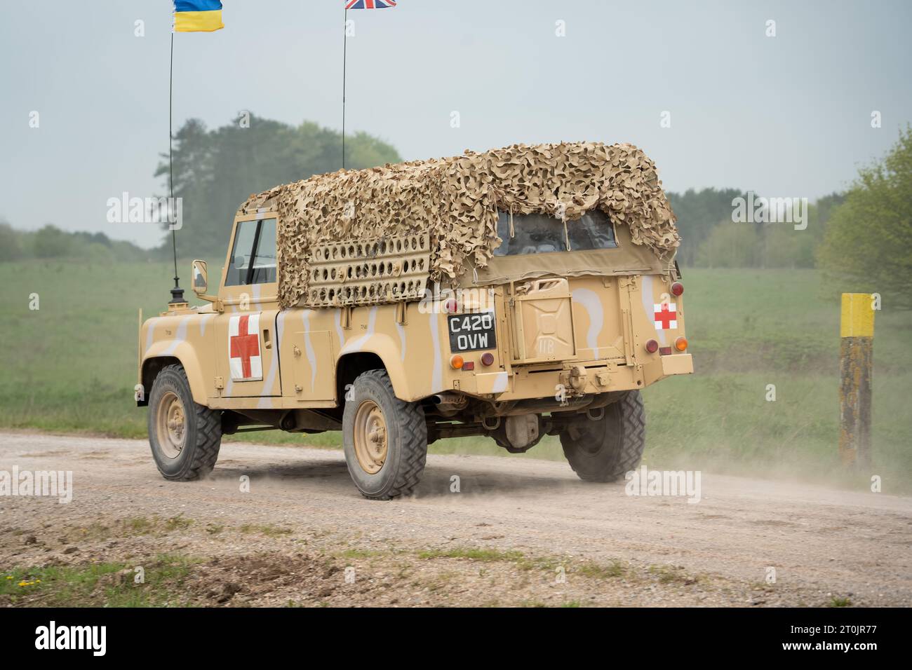 an old military ambulance land rover defender wolf, driving along a dirt track Stock Photo