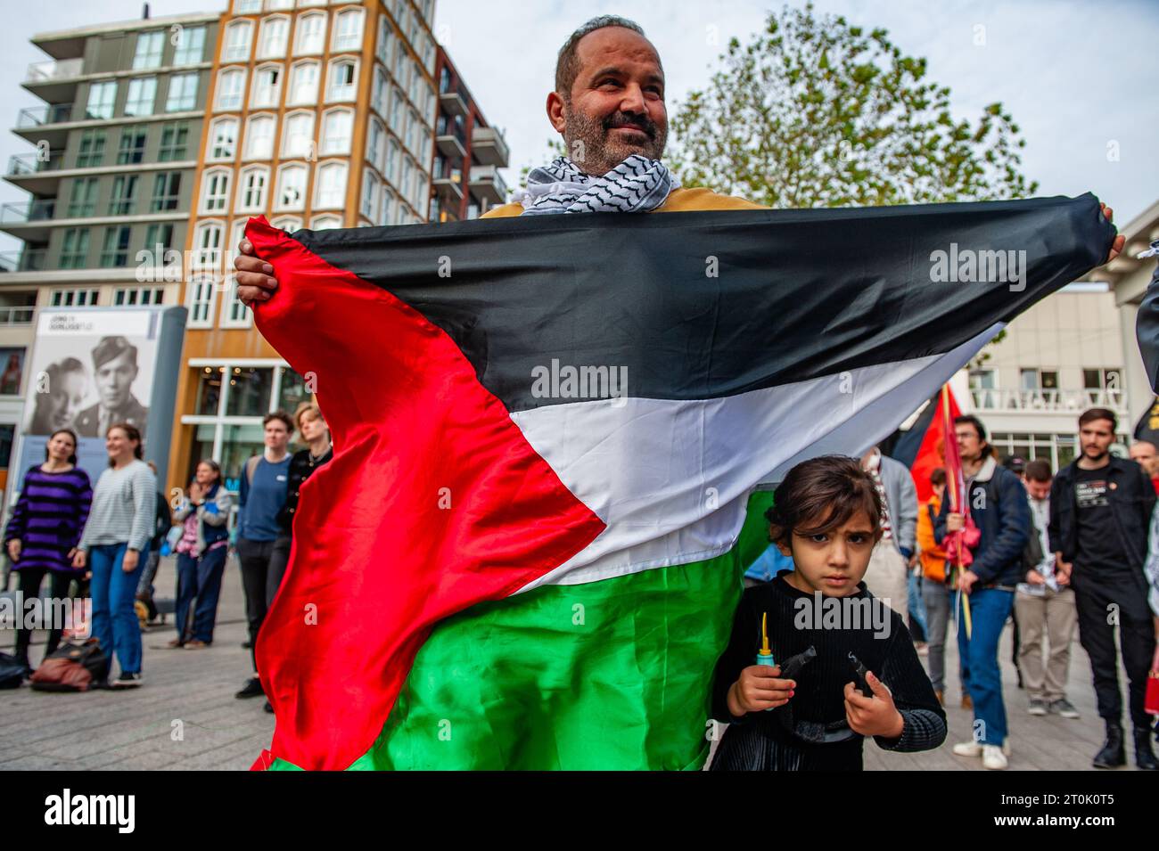 Nijmegen, Netherlands. 07th Oct, 2023. A protester is seen holding a Palestinian flag with her daughter on his side during the demonstration. This week marks ten years since the tragedy of Lampedusa, where more than 350 migrants died in a boat carrying migrants from Libya to Italy. People gathered in the city center to ask for a humane reception, stop Frontex (The European Border and Coast Guard Agency), and treat migrants with fair human right. This protest is an initiative to 'Stop Racism Platform' organizations. Credit: SOPA Images Limited/Alamy Live News Stock Photo