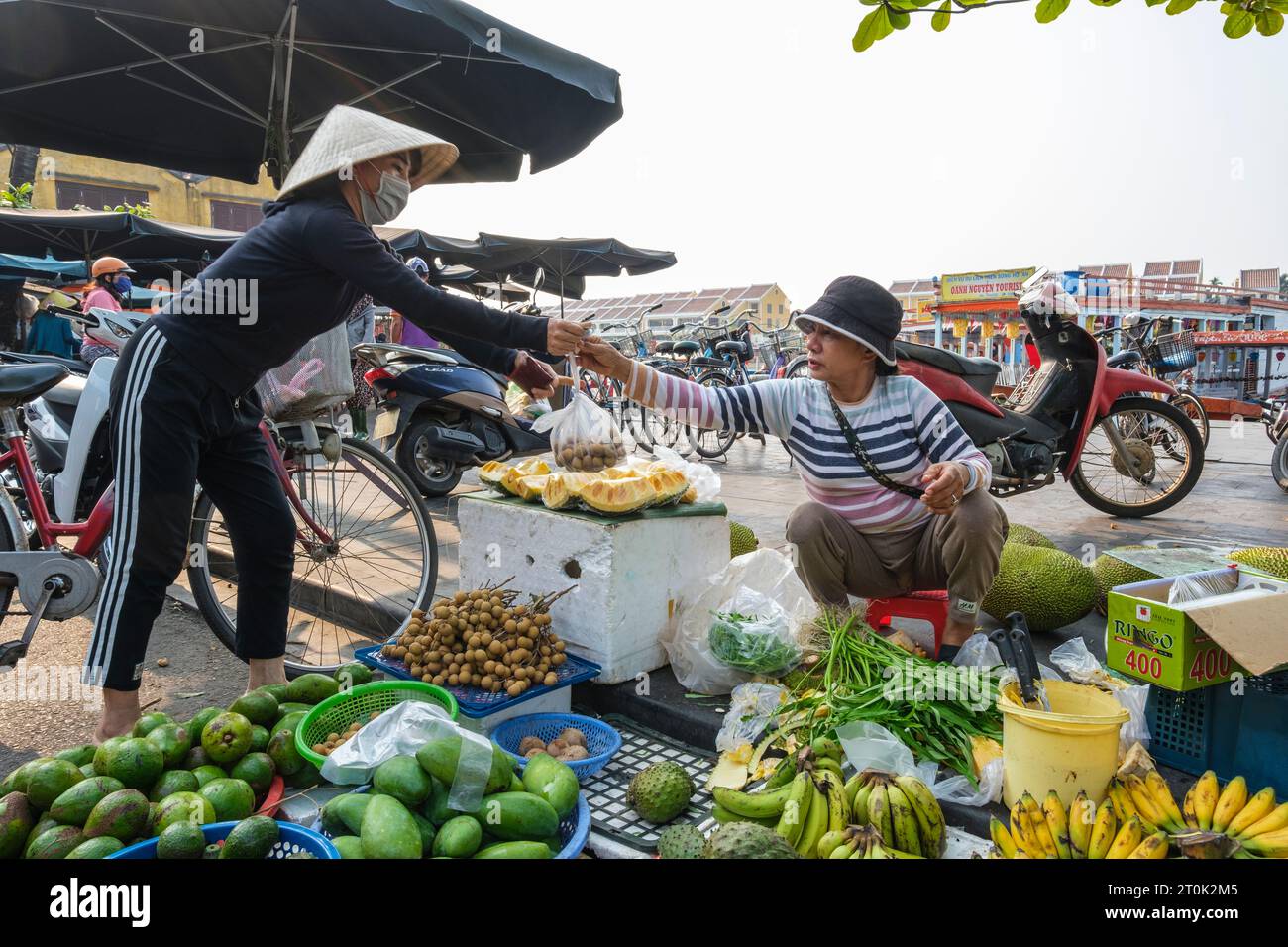Hoi An, Vietnam. Fruit and Vegetable Vendor with Customer. Stock Photo