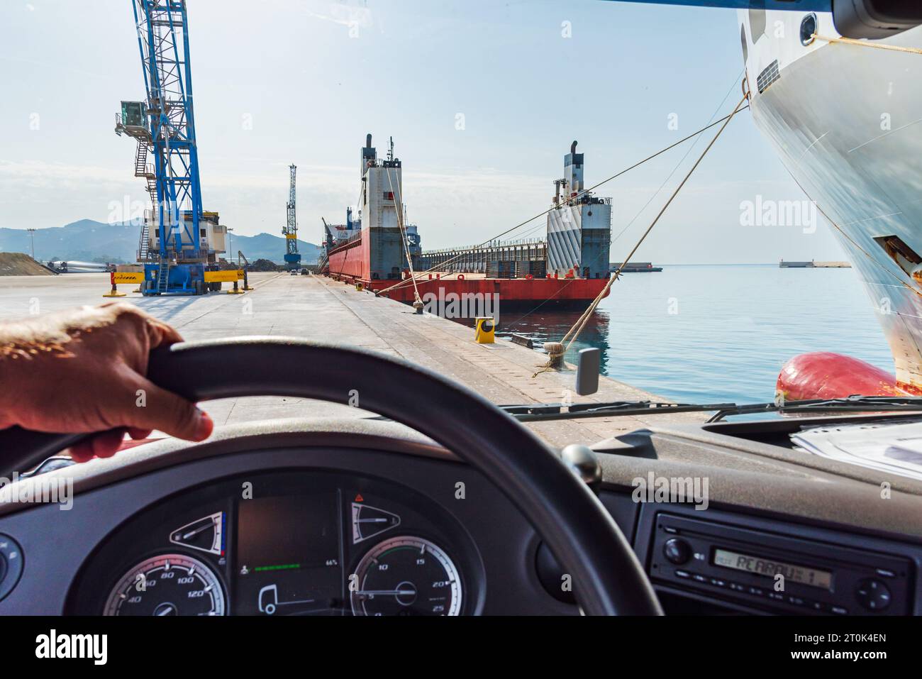 View from the driving position of a truck of a merchant ship docked at a port dock . Stock Photo