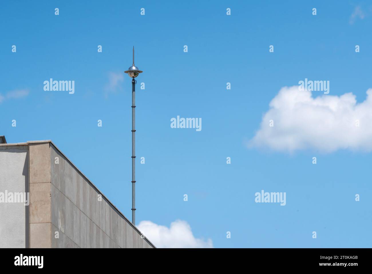 Lightning rod on the roof of a building against a blue sky. Lightning strike Stock Photo