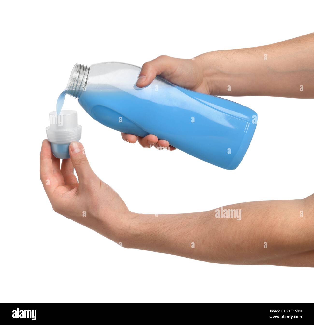 Man pouring fabric softener from bottle into cap for washing clothes on