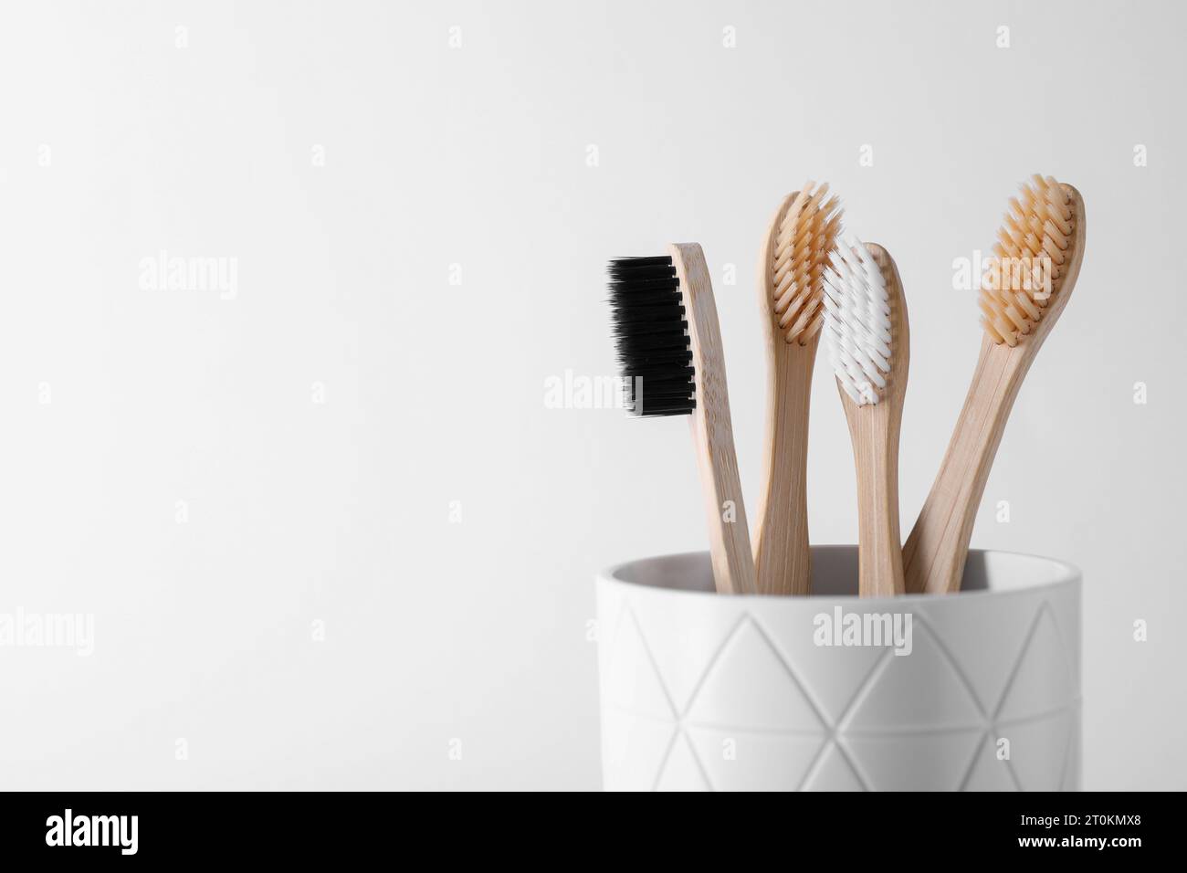 Bamboo toothbrushes in holder on white background, space for text Stock ...