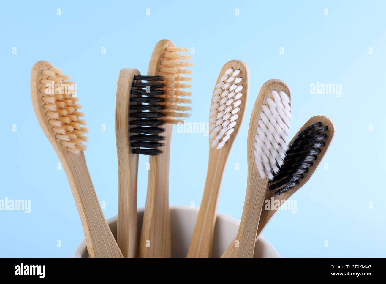 Bamboo toothbrushes in holder on light blue background, closeup Stock ...
