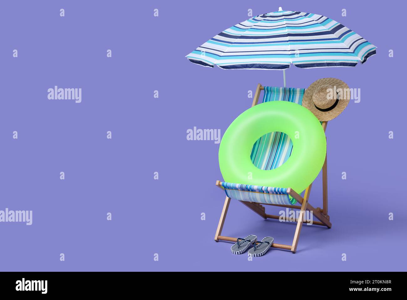 Deck chair, umbrella and other beach accessories on purple background ...
