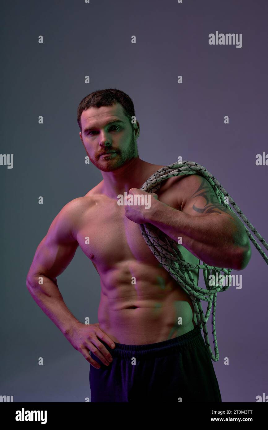 shirtless strong man with perfect abs holding battle ropes full length photo isolated blue background studio shot, sportsman holding sport equipment a Stock Photo