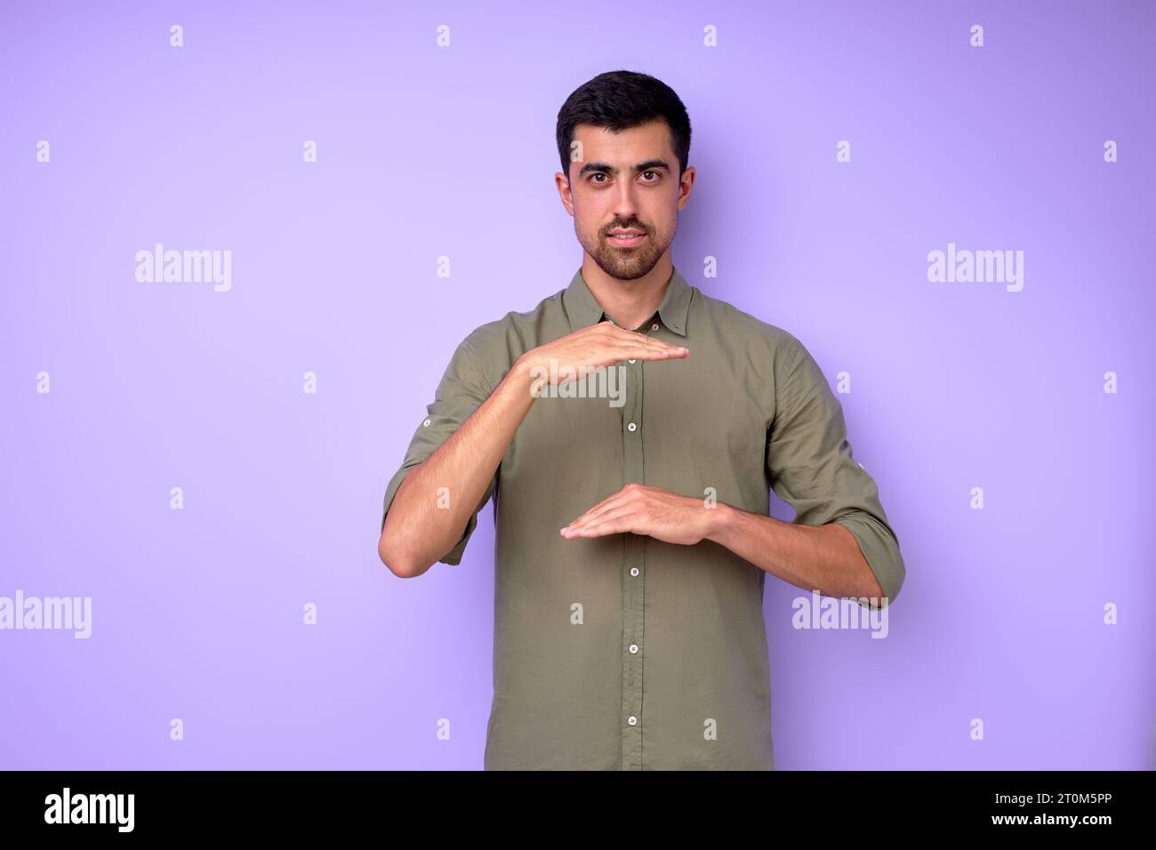 Young deaf mute man saying celling using sign language on blue background, close up portrait isolated building house concept Stock Photo