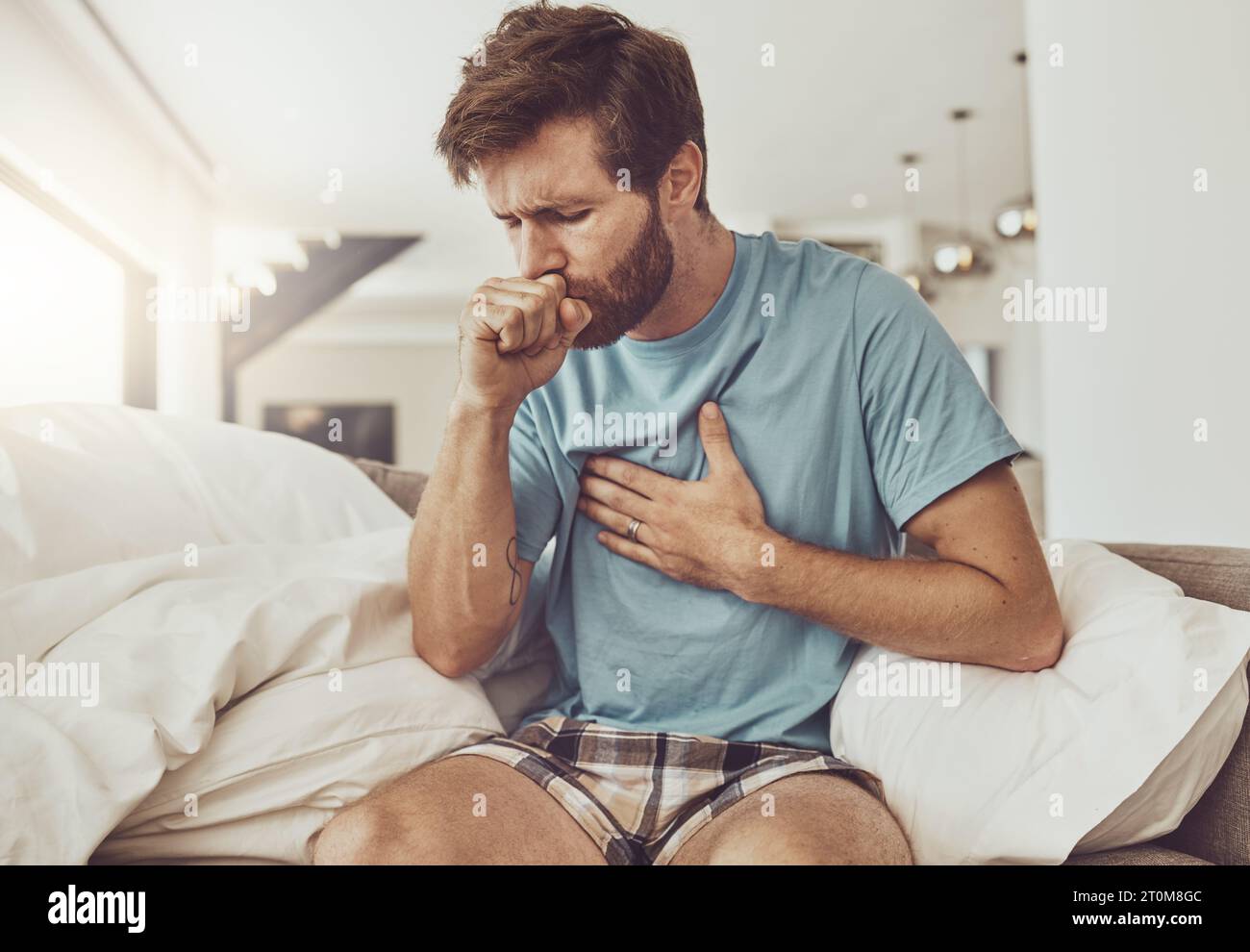 Sick, coughing and man on a sofa with chest pain, tuberculosis or