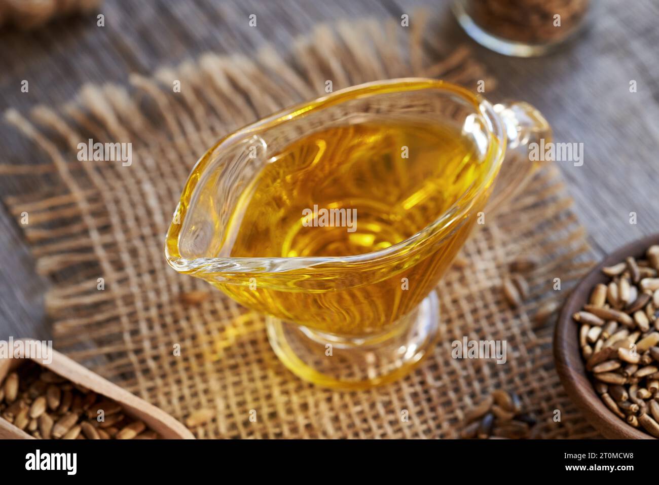 Milk thistle oil in a glass jug with Carduus marianus seeds Stock Photo