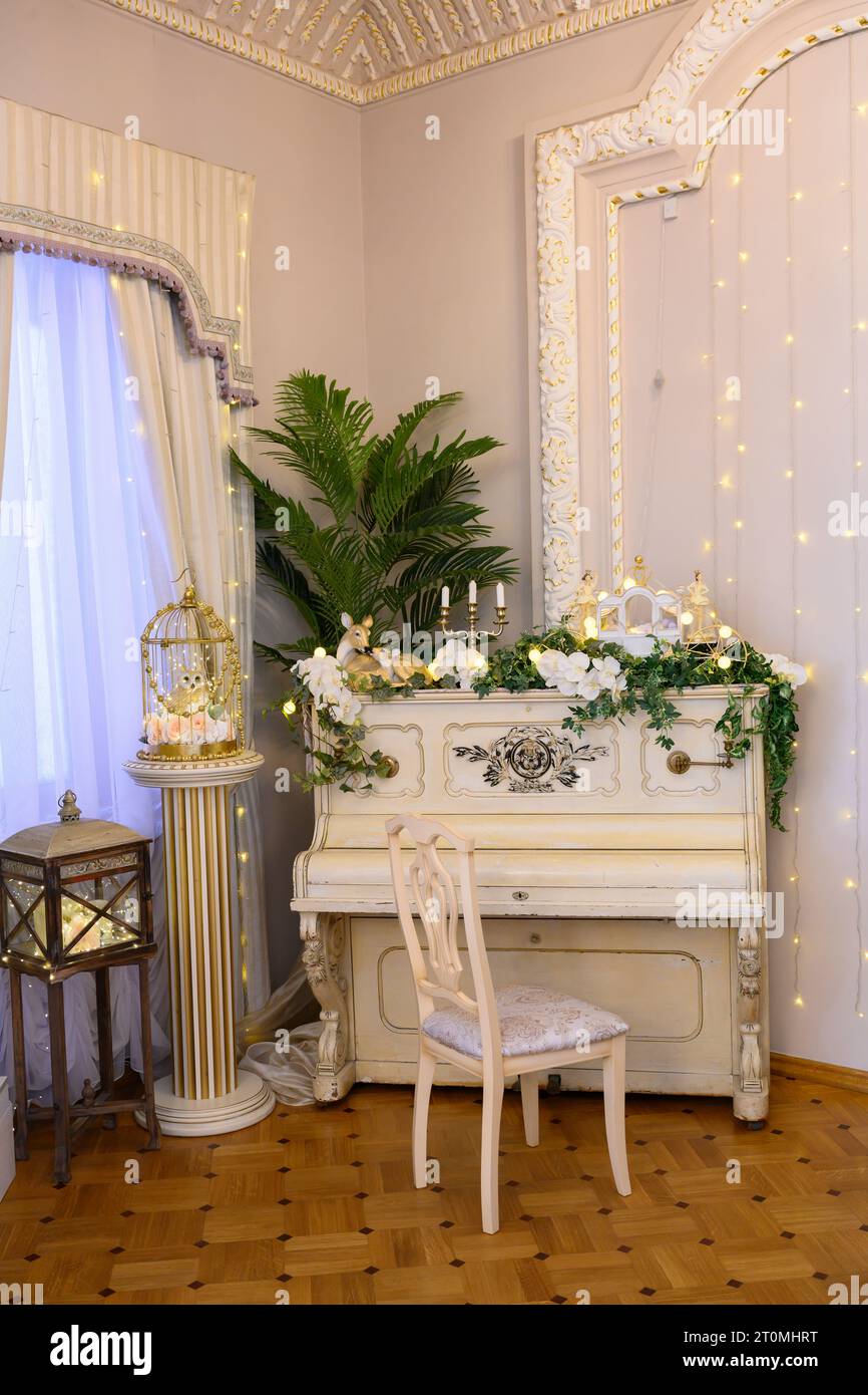Antique white piano with flowers and sculptures in the interior of a ...