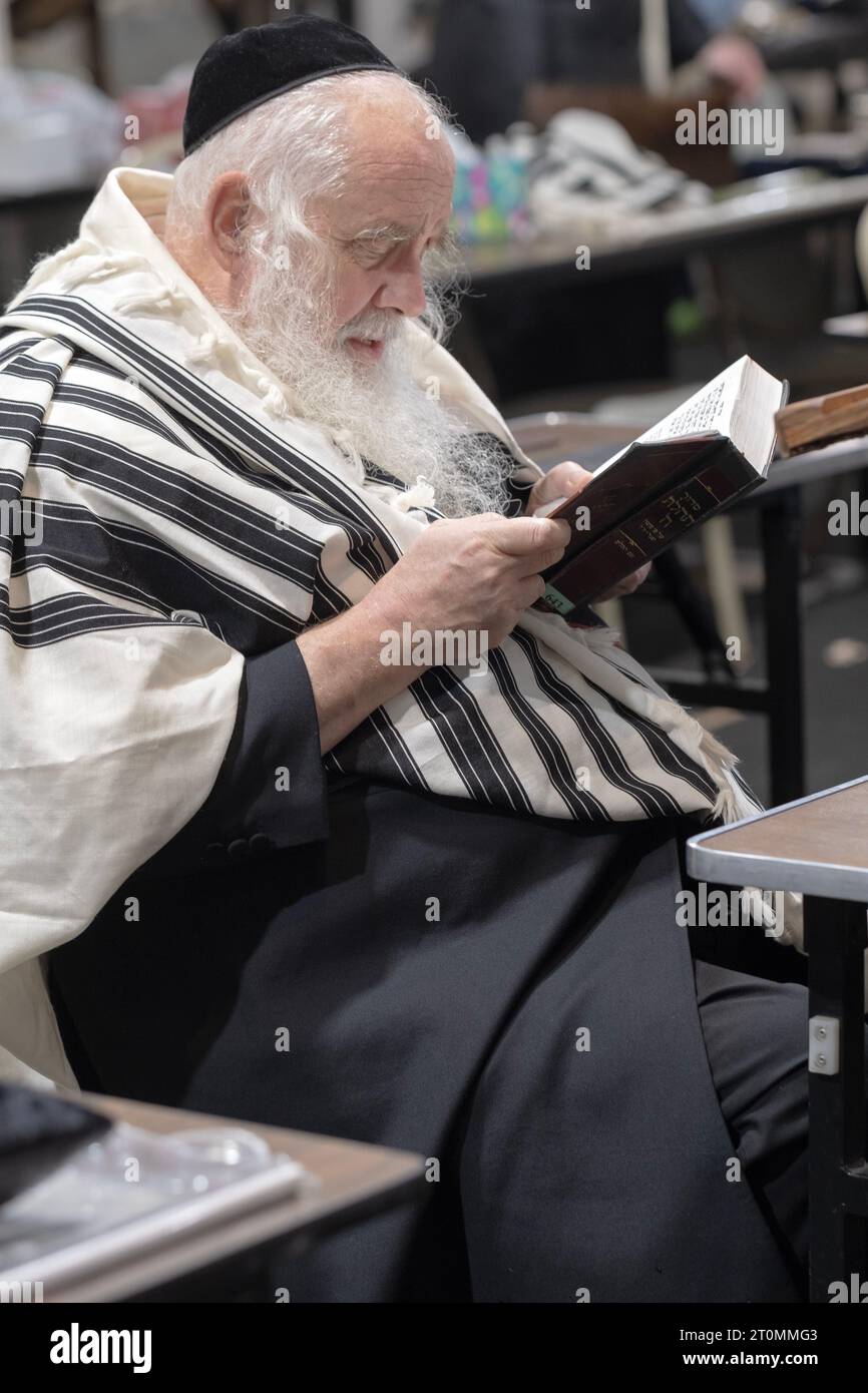An older orthodox Jewish man recites morning prayers during the Sukkos