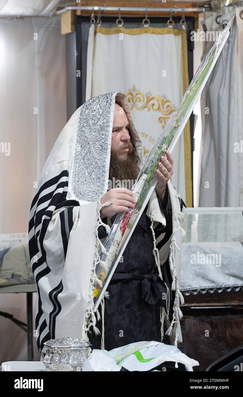 After Sukkos morning services an orthodox Jewish man outs his lulav in a plastic case. In a synagogue in Rockland County, New York. Stock Photo