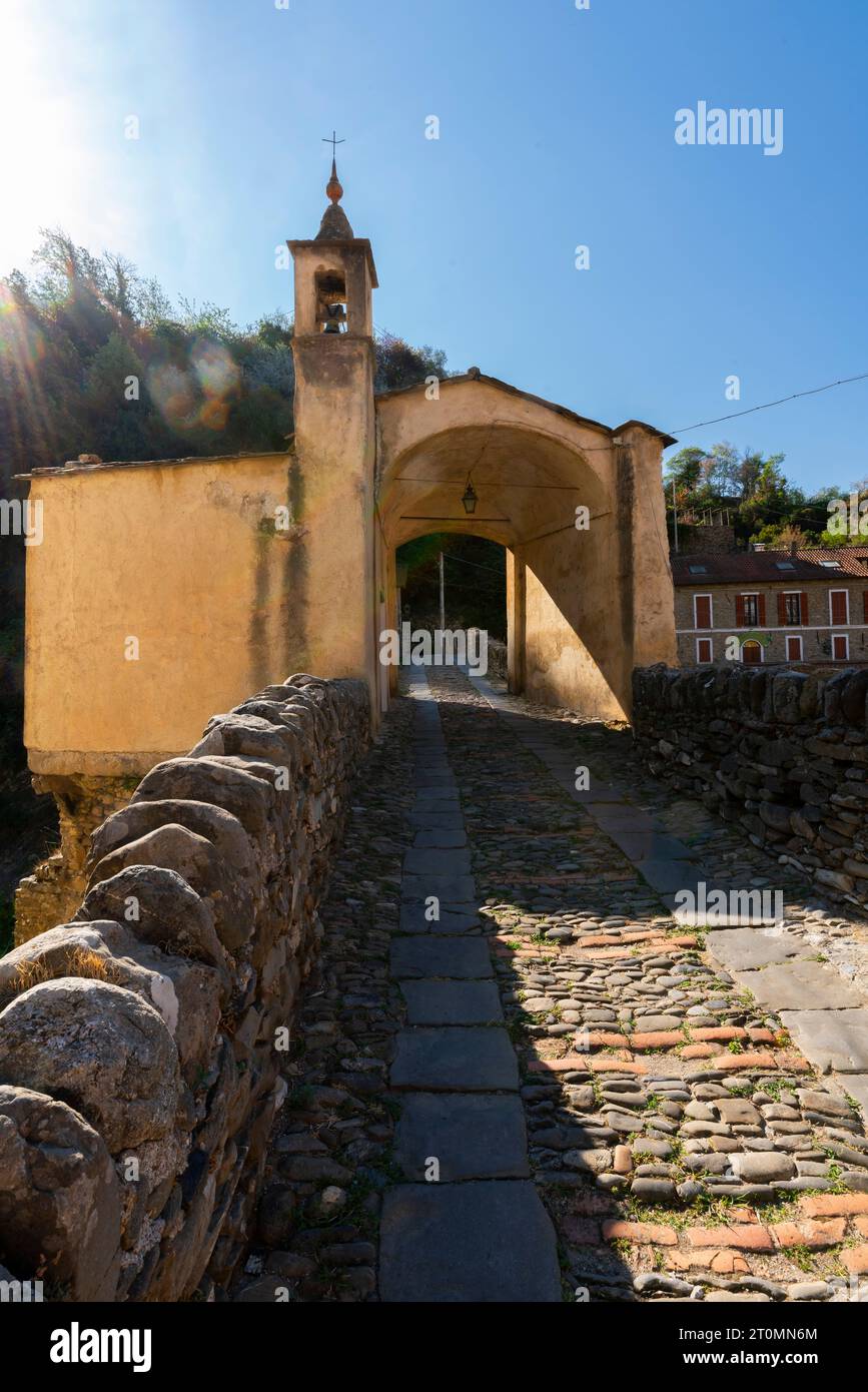 Medieval stone bridge over Argentina river and chapel in small town Badalucco. Badalucco is a comune in the Province of Imperia, Italy. Stock Photo