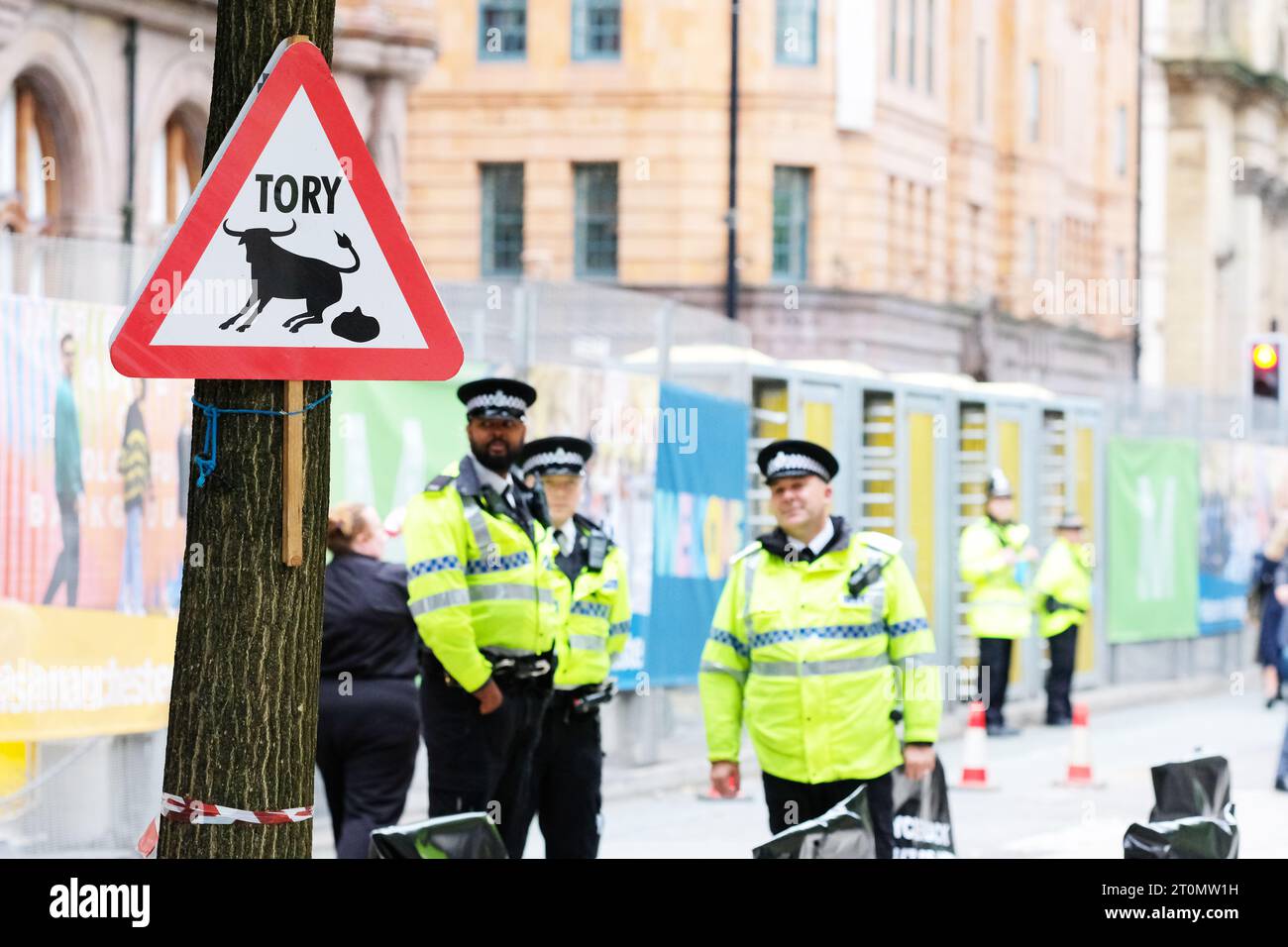 Conservative Party Conference a spoof joke sign warning of Tory bullshit outside the Midland Hotel Manchester nearby GMP Police officers in Oct 2023 Stock Photo