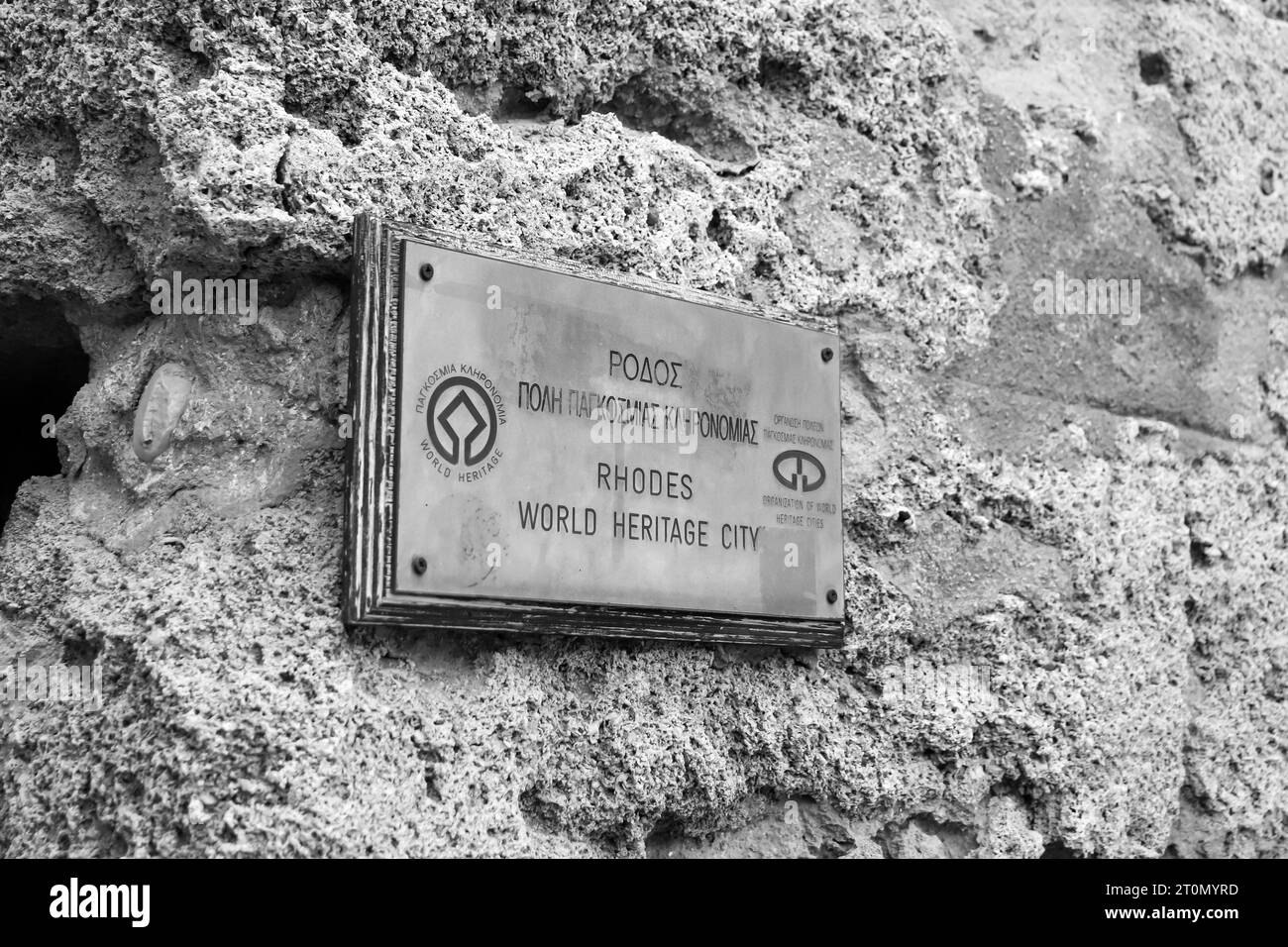 Rhodes World Heritage City sign hung at the Gate of Amboise entrance to Old Town, Rhodes in black and white Stock Photo